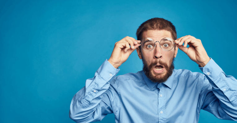 Überraschter Mann mit Brille- symbolisch für unerwartete Fehler beim Hausverkauf, die Eigentümer vermeiden sollten