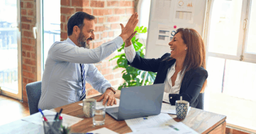 Zwei Menschen die sich nach einer erfolgreichen Entscheidung freudig abklatschen