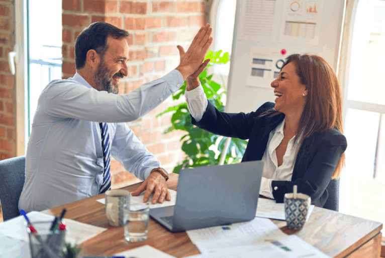 Zwei Menschen die sich nach einer erfolgreichen Entscheidung freudig abklatschen